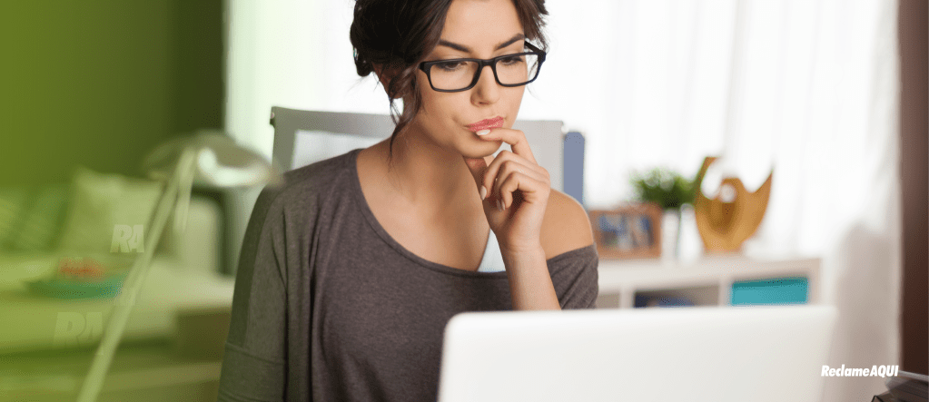 Mulher olhando para tela do computador com cara de dúvida
