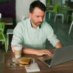 Homem utilizando notebook, representando usuário verificando lista de serviços de streaming bloqueados