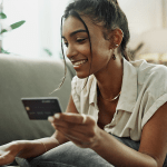 Mulher usando cartão de crédito para compra online durante a Black Friday, atenta a possíveis golpes