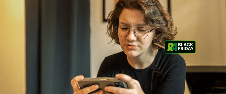 onsumidora preocupada olhando celular, verificando site falso na Black Friday 2025