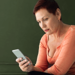 Mulher olhando o celular pra entender os principais problemas que estão acontecendo na Black Friday 2025