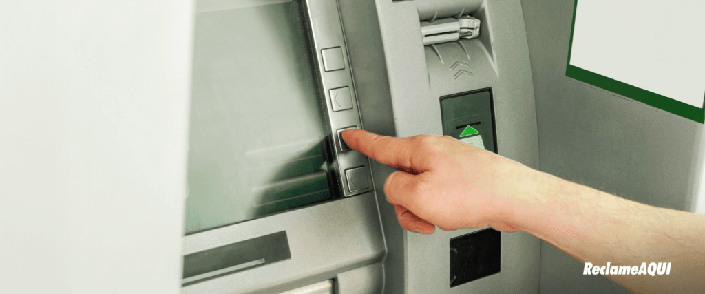 Caixa eletrônico com mão de usuário, ilustrando a segurança bancária e a nova trava do Banco Central