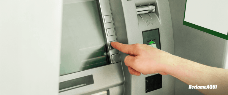 Caixa eletrônico com mão de usuário, ilustrando a segurança bancária e a nova trava do Banco Central