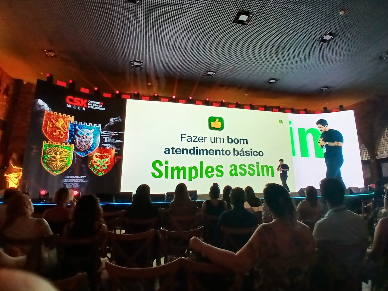 Slide de apresentação no evento CSX Week com um ícone de polegar para cima e a frase 'Fazer um bom atendimento básico: Simples assim' em destaque.